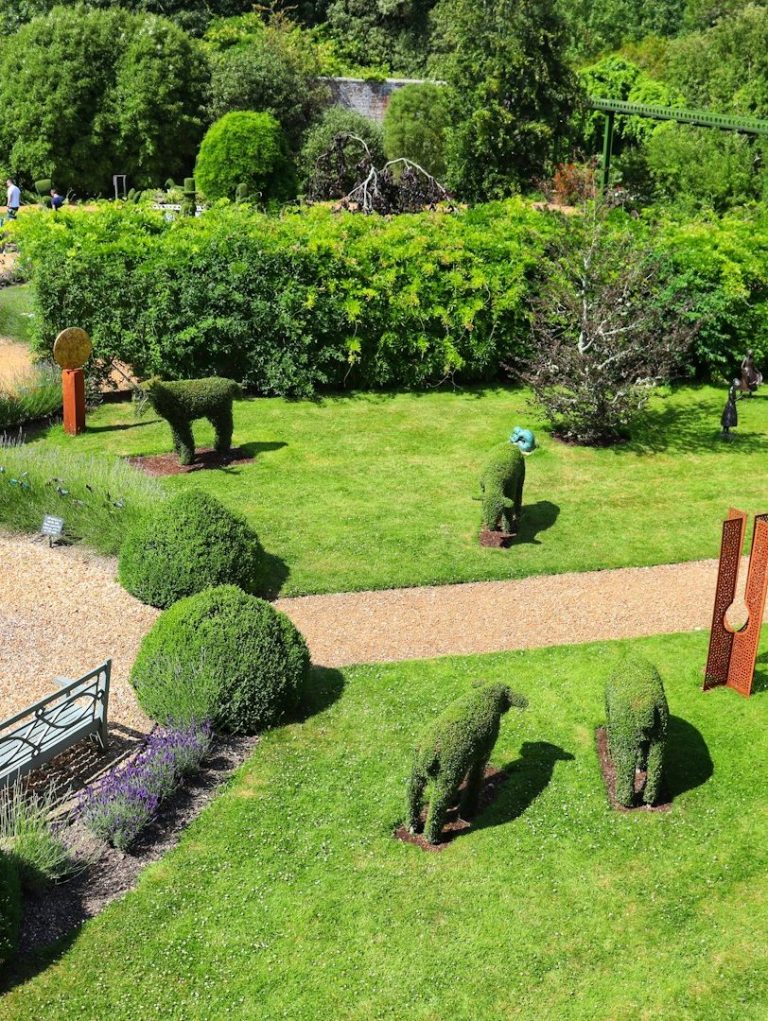 Garten Topiaries in Form von Tieren in einem gepflegten Garten mit bunten Pflanzen.